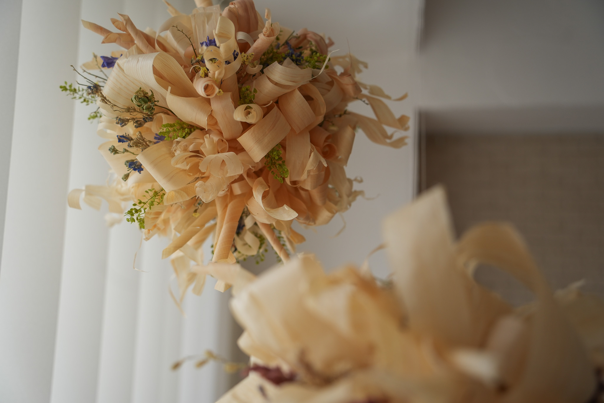 カンナ屑と草花を束ねた丸い作品の細部